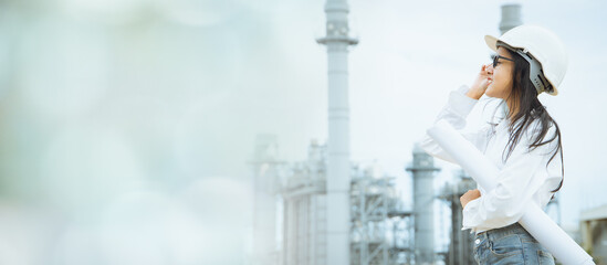 Professional engineer women with blueprint at petroleum or petrochemical or power plant building wide for industry banner advertising. © Quality Stock Arts