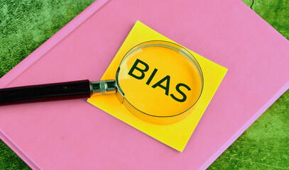 Personal opinions prejudice bias concept. BIAS through a magnifying glass on a yellow sticker, a concept photo