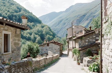 A photo of an Italian mountain village with stone walls and road, taken from the street in summer. A man is walking on the road, with mountains in the background. The photo has a 35mm film grain and i