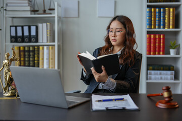A bespectacled lawyer or legal consultant working at the level of justice sits at a table and holds a pen to view information. Detailed content about jurisprudence to study in the field of law.