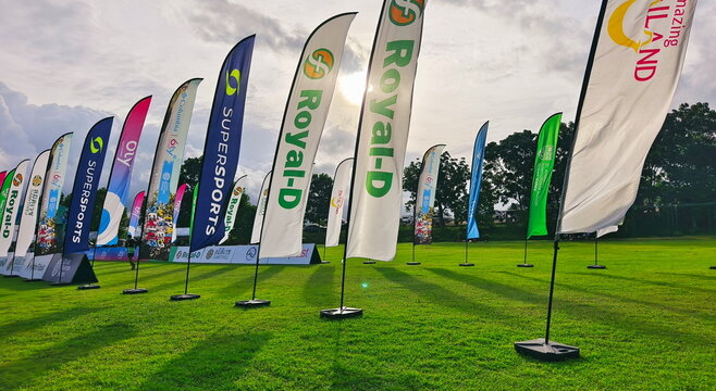 Outdoor advertising feather flags on green field 
