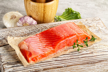 Raw salmon fillet over board