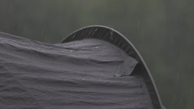 Raindrops on tent. Tourist equipment in wildlife in wet season. Close-up shot of raindrops on the tent. Rain is pounding on tent. Slow motion video ProRes 422 10bit ungraded C-LOG