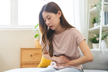 Flatulence asian young woman intolerance hand in stomach ache, suffer from food poisoning,...