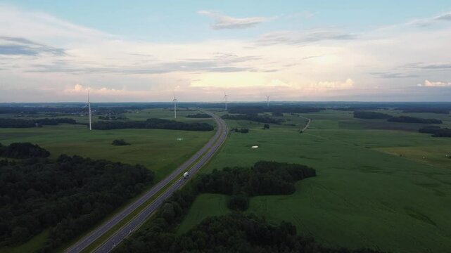 Road to green energy wind turbines producing electricity next to highway road