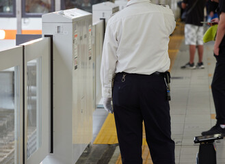 夏の名古屋駅のホームで仕事する男性駅係員の姿