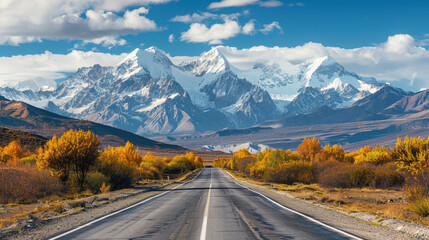 Fototapeta premium Scenic mountain road winds through a lush green forest under a bright summer sky