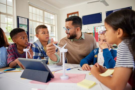 Male teacher explaining wind turbines to students