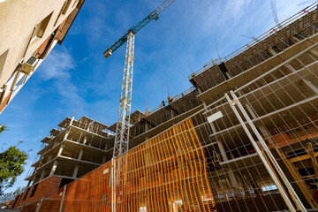 Construction site fenced with plastic orange safety mesh, hollow quadratic shape, fence