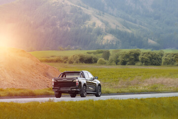 Fototapeta premium Black pickup crew cab truck on a countryside road at sunset