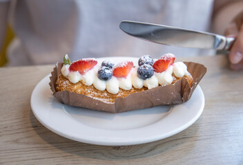 A person is cutting a dessert with a knife
