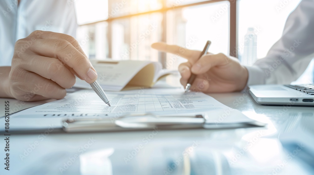 Poster hands of a financial advisor showing a tax document to a client, with the advisor's finger pointing 
