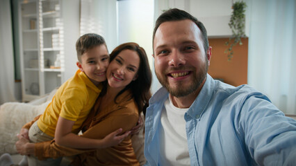 Happy Caucasian family talking on online video call wave hello greeting looking at webcam father mother son bloggers recording vlog parents kid boy child communicate together remote on device at home