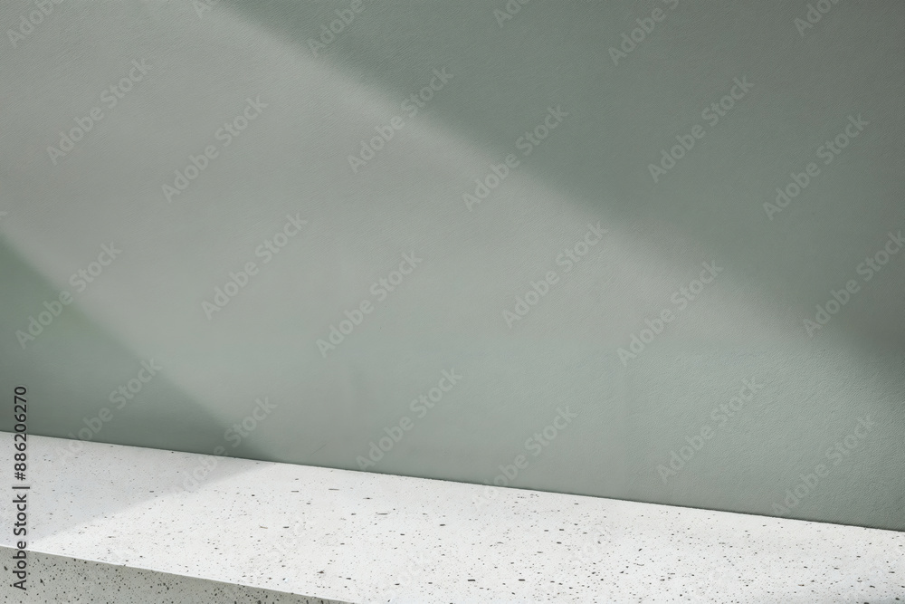 Poster empty terrazzo tabletop on green wall with falling light beam for product placement