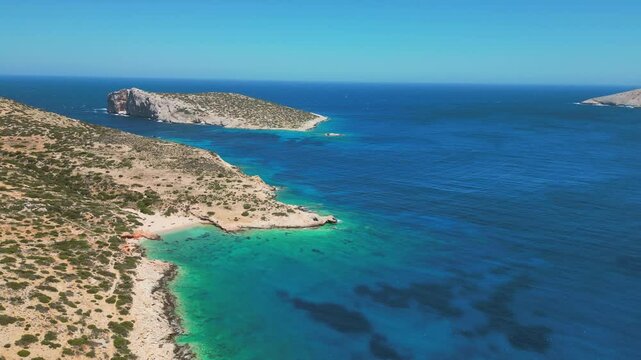 A tranquil aerial view of Donousa, showcasing the island's rugged coastline, turquoise waters, and lush vegetation.