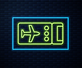 Glowing neon line Airline ticket icon isolated on brick wall background. Plane ticket. Vector