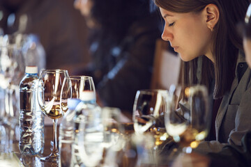 Woman Sitting at Table Surrounded by Wine Glasses during Wine Tasting