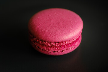 Pink macaroni on a black background. Macaroni is the only thing visible in the image.