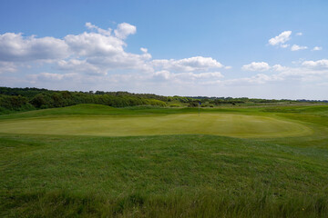 View over golf course on summer day. sport and leisure. Golf hole with fairway and putting green 
