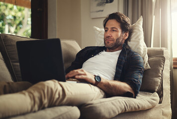 Relax, laptop and man in home for remote work, reading email and social media. Computer, web and...
