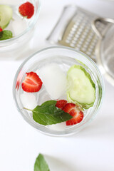 Glass of Water with Lemon Juice, Mint, Strawberry, Cucumber and Ice Cubes. Refreshing Water.