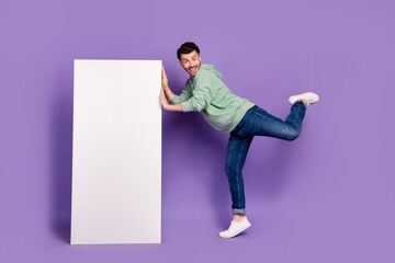 Full body photo of attractive young man playful lean vertical menu poster wear trendy gray clothes isolated on violet color background