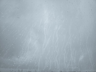Raindrops and steam condensation on glass windowpane in rainy day.
