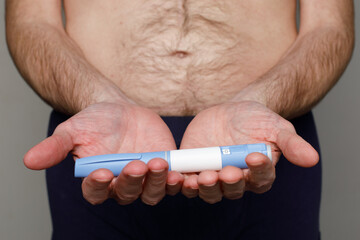 Insulin or semaglutide injection pen or insulin cartridge pen for diabetics in male hands.