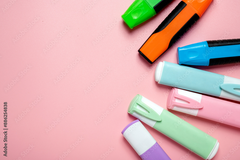 Poster a row of markers of various colors are on a pink background
