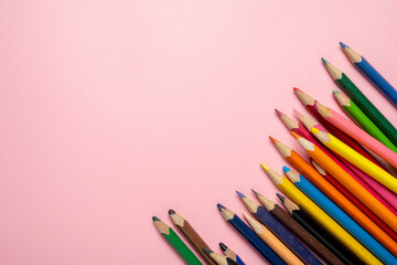 Fototapeta premium A row of colored pencils on a pink background