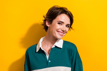 Obraz premium Photo of pretty satisfied young girl beaming toothy smile wear shirt isolated on yellow color background