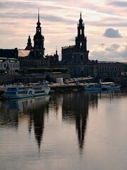 Naklejka premium Brühl's Terrace - A twilight photo of the Elbe with the Court Church and old town silhouette in the background. The high-contrast scene depicts Dresden, Saxony.