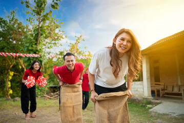 A group of people are playing a game of sack race