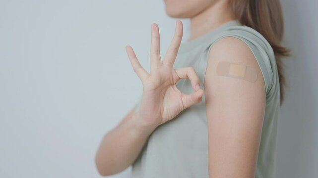 Woman with bandage after receiving vaccine. Vaccination and Immunization for Influenza, HPV, Zoster, IPD, DTP or Diphtheria, Tetanus and Pertussis, MMR, Hepatitis B, Covid  and Varicella vaccine