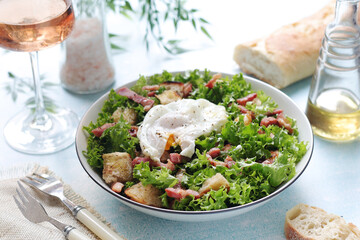 A bowl with salad lyonnaise served for lunch	
