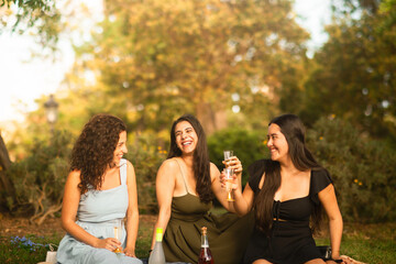 girlfriends laughing being happy at the park with a drink