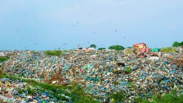 Endless amounts of pollution as birds fly above a mountain of trash and plastic in a landfill in Bangladesh.