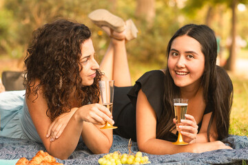 girlfriends laughing being happy at the park with a drink