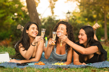 girlfriends smiling being happy at the park with a drink
