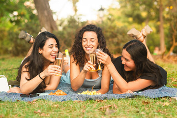 girlfriends smiling being happy at the park with a drink