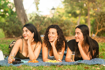 girlfriends looking on the left smiling and being happy at the park