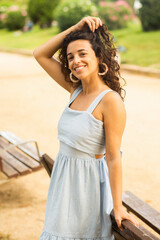 woman relaxing in the park with beautiful smile in blue dress
