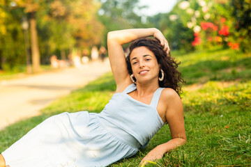 curly haired woman relaxing in the park with beautiful smile