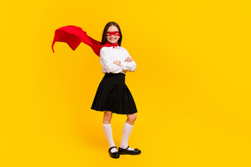 Full size photo of cute schoolgirl superhero crossed arms empty space wear uniform isolated on yellow color background © deagreez