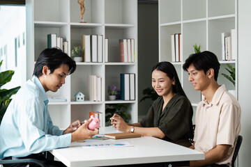 Young Couple Planning Savings and Banking with Financial Advisor in Modern Office Setting