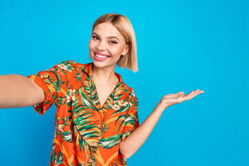 Photo of lovely cute girl wear trendy orange print clothes hold empty space isolated on blue color background