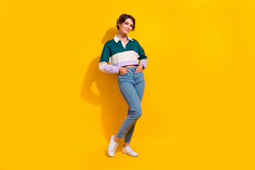 Fototapeta premium Full length photo of cute adorable lady dressed polo shirt smiling walking empty space isolated yellow color background