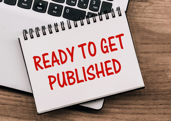 A White Notebook With Red Text Ready To Get Published On A Wooden Desk