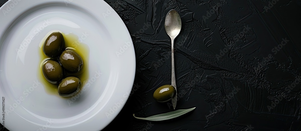 Poster blank white plate features fresh olives and olive oil with a spoon against a black background creati