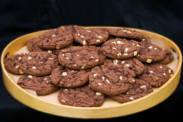 Tempting chocolate chip cookies on a wooden board.